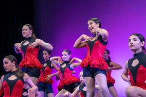 students on stage wearing red costumes